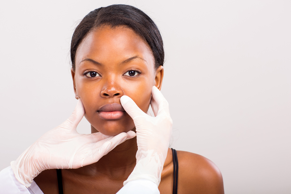 doctor checking african woman lips before plastic surgery